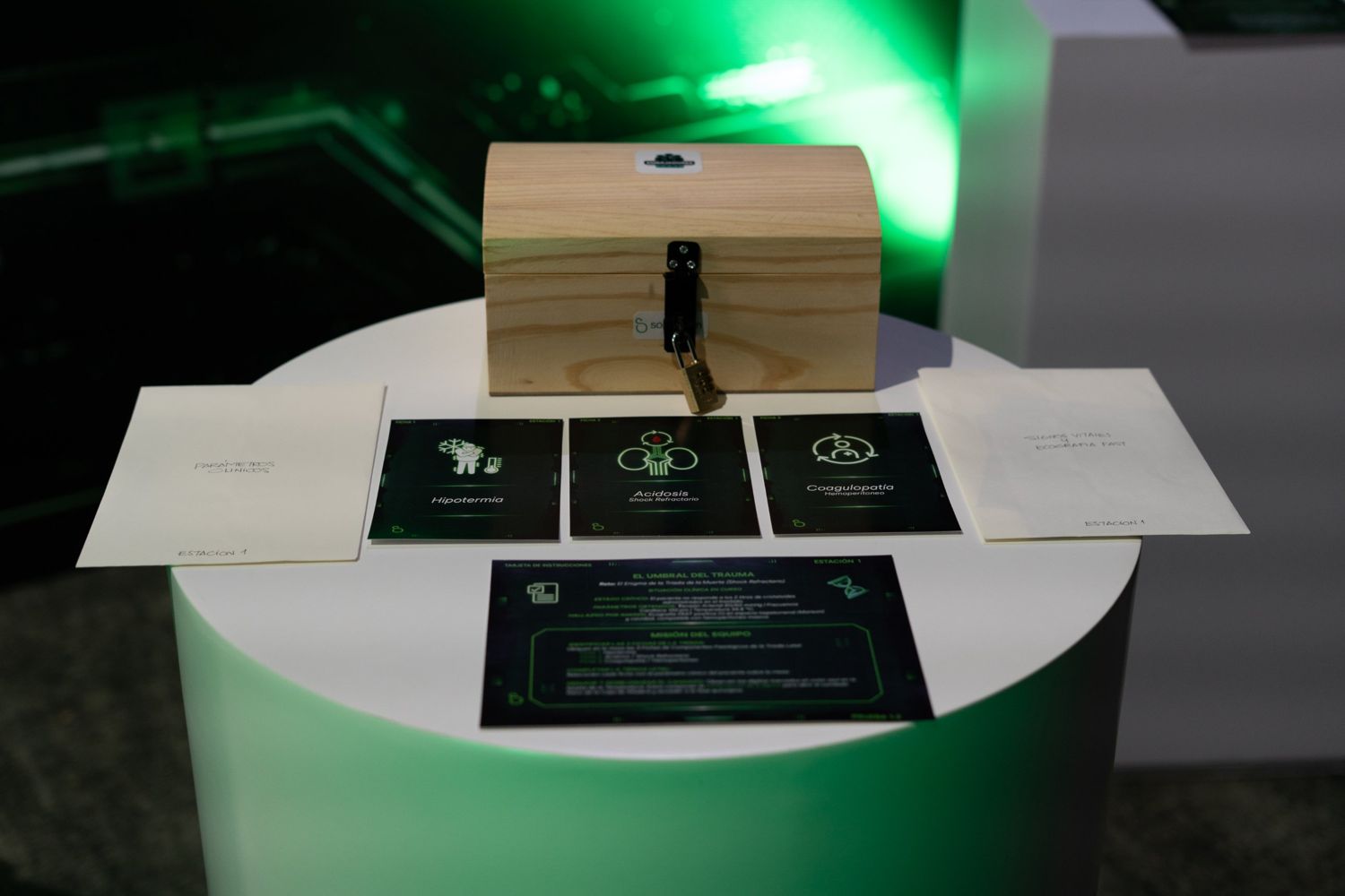 Estación de un escape game médico con un cofre con candado y tarjetas de casos clínicos