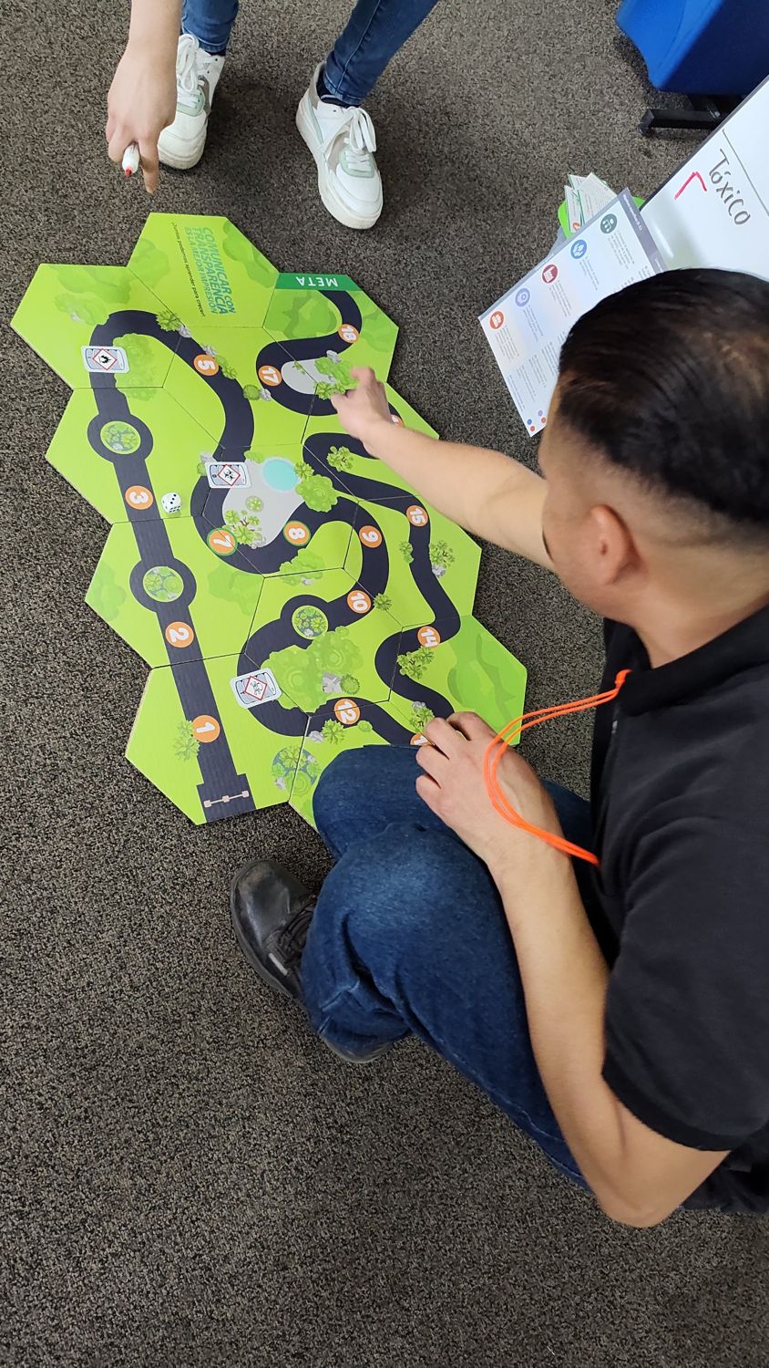 Un participante juega en un tablero hexagonal sobre comunicación y manejo de sustancias